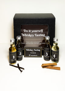 Vier Whiskeyflaschen von tastingerlebnis.de stehen vor schwarzem Karton mit der Aufschrift "Do it yourself Whiskey Tasting"